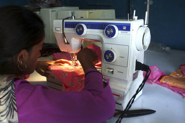A woman sews clothes on a sewing machine driven by solar energy in Ahmedabad in western India. When night falls in remote parts of Africa and the Indian subcontinent, hundreds of millions of people without access to electricity turn to candles or flammable and polluting kerosene lamps for illumination. Solar power is becoming an economical way to bring light to these rural regions where a lack of electricity has stymied economic development, literacy rates, and health.  <P>Amit Dave/Reuters/File