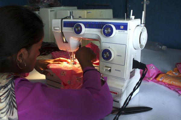 A woman sews clothes on a sewing machine driven by solar energy in Ahmedabad in western India. When night falls in remote parts of Africa and the Indian subcontinent, hundreds of millions of people without access to electricity turn to candles or flammable and polluting kerosene lamps for illumination. Solar power is becoming an economical way to bring light to these rural regions where a lack of electricity has stymied economic development, literacy rates, and health. <P>Amit Dave/Reuters/File