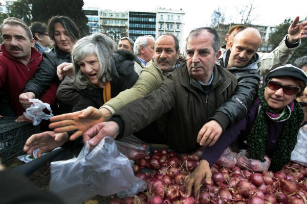 Greeks wait to receive free onions and other vegetables offered by farmers in Syntagma Square in Athens last January. In the US, many organizations work to share leftover fruits and vegetables with those in need, based on the ancient idea known as gleaning.  <P>Yannis Behrakis/Reuters/File