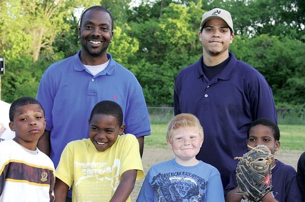 Cle Ross (back l., with Marquis Roby Sr., a KCK RBI league coach, and youth baseball players) was given sports equipment anonymously as a child and eventually played minor league baseball. Now he helps urban youths through Major League Baseball’s Reviving Baseball in Inner Cities program.  David Conrads