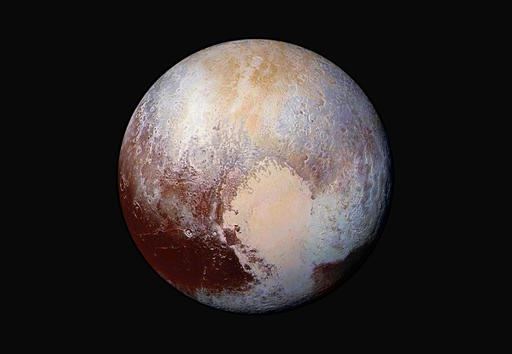 This image made available by NASA on July 24, 2015 shows a combination of images captured by the New Horizons spacecraft with enhanced colors to show differences in the composition and texture of Pluto's surface. The deep icy basin in Pluto's heart-shaped region may be a natural sinkhole. In a study published Wednesday, Nov. 30, 2016, a team led by University of Maryland astronomer Douglas Hamilton suggests the basin may have resulted from the weight of surface ice. (NASA/JHUAPL/SwRI via AP)