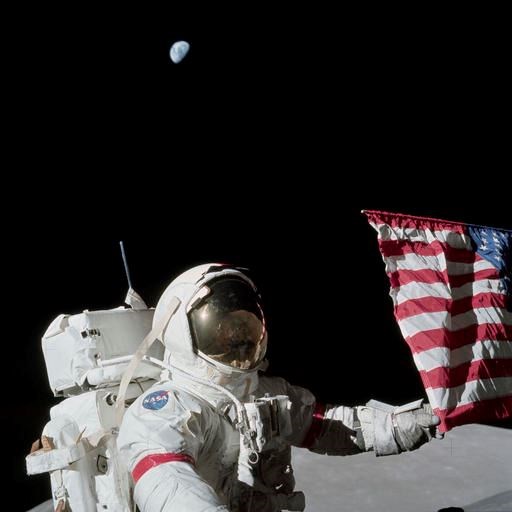 n this Dec. 12, 1972, photo provided by NASA, Apollo 17 commander Eugene Cernan holds the lower corner of an American flag during the mission's first Extravehicular activity on the moon. NASA announced that former astronaut Cernan, the last man to walk on the moon, died Monday, Jan. 16, 2017, surrounded by his family. He was 82. (Harrison J. 