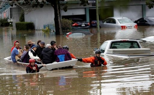 Rescue crews take out residents from a flooded neighborhood Tuesday, Feb. 21, 2017, in San Jose, Calif. Rescuers chest-deep in water steered boats carrying dozens of people, some with babies and pets, from a San Jose neighborhood inundated by water from an overflowing creek Tuesday. (AP Photo/Marcio Jose Sanchez)