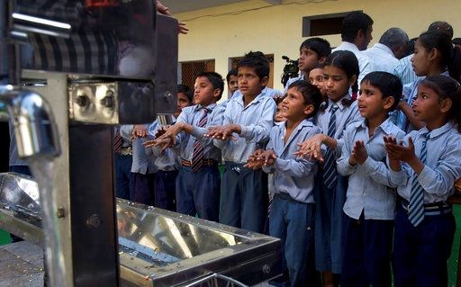 Schoolchildren learn to wash their hands before drinking water from newly set up water filtration tower in their school in Nai Basti Village, some 55 kilometers (35 miles) from in New Delhi, India, Wednesday, March 22, 2017. Schoolchildren cheered and village women clapped as a gush of clean water flowed through a set of gleaming steel taps connected to a newly installed water filtration plant in a dusty north Indian village on Wednesday. (AP Photo/Manish Swarup)