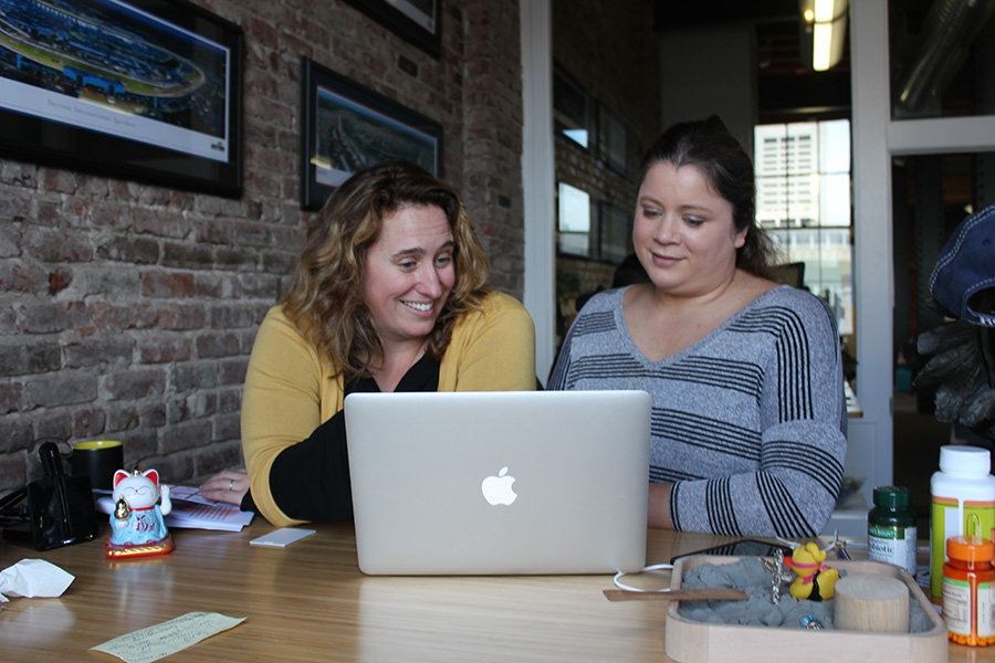 Employees Meredith Arthur (left) and Jessica Grant commmandeer a co-worker’s office at the San Francisco headquarters of Outdoorsy, an online RV marketplace, on March 6. Here “there’s an inclusiveness that has not been at other startups I’ve been in,” Ms. Grant says. (Jessica Mendoza/The Christian Science Monitor)