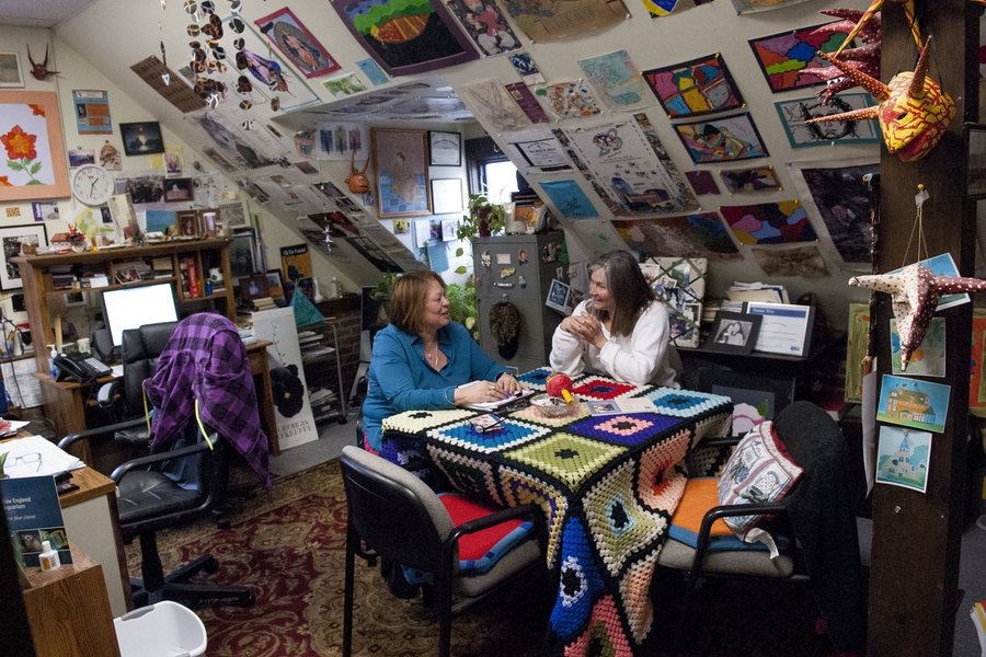 Care Center director of education Ana Rodriguez (l.) and executive director Anne Teschner (r.) discuss the history of the school and microcollege for teen mothers in Ms. Rodriguez’s attic office in Holyoke, Mass, March 7, 2017. The Care Center offers a range of supports to teen mothers and teaches classes that enable them to attain their HiSet, a high school equivalency exam. Last August, the center opened a first-in-the-nation microcollege to allow some of its high school graduates to earn a liberal arts associate's degree. (Josh Kenworthy/The Christian Science Monitor)