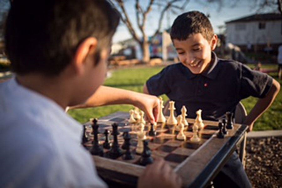 Two boys play chess at Pogo Park in Richmond, Calif. (photo courtesy of Pogo Park)
