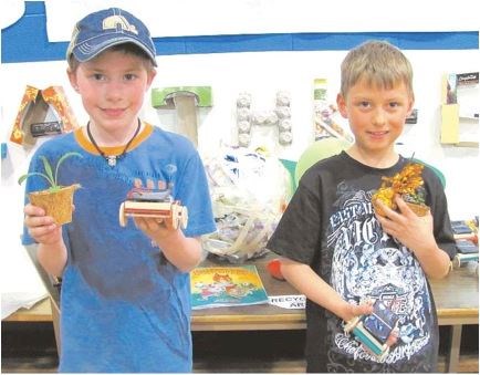 Max McGrath (gr.4) and Chays Hall (gr. 2) display their seedlings, solar-powered cars and an upcycled object at Notre Dame Elementary school's celebration of heroes on May 2. Both of the Morinville students chose to learn about eco-friendly earth keeper heroes, with McGrath saying "I like paleontology and stuff about the dinosaurs and the earth."