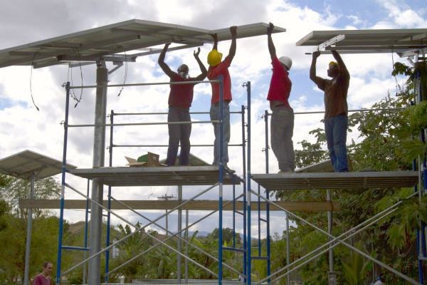 People install solar panels on the Saint-Michel health center and a fish hatchery in Boucan Carre, Haiti. The panels will provide the town with a dependable electricity supply for the first time. Only a quarter of Haiti's 10 million people has regular access to electricity. In 28 countries, Barefoot College is teaching people to harness solar power for electricity. <P>Dieu Nalio Chery/AP/File