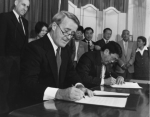 Brian Mulroney and Art Miki signing redress settlement papers