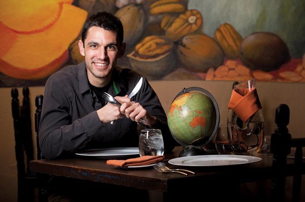 Eric Maddox, founder of the Virtual Dinner Guest Project, sits at a table at the Epazote Restaurant in Santa Fe, N.M. Mr. Maddox hosted a virtual dinner here with diners in Ciudad Juárez, Mexico, in the fall via Skype. He and others have also held a dinner/breakfast meeting with a group in Karachi, Pakistan. <P>Kerry Sherck/Special to The Christian Science Monitor