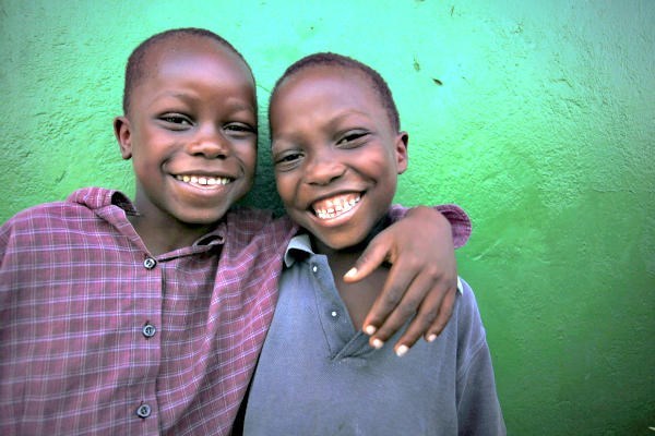 Two boys laugh as they pose for a photo in a neighborhood of Monrovia, Liberia. Aids groups such as Oxfam would like to portray the people they help as trustworthy partners capable of helping themselves, and not as victims. But publicity campaigns that show a suffering 'poster child' remain more effective in eliciting donations.  <P>Thierry Gouegnon/Reuters