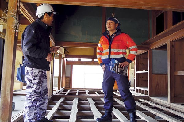 Seiji Yoshimura (r.), who responds to disasters throughout Asia, talks to carpenter Kenji Hoshino at a tsunami-struck house in Ishinomaki, Japan. <P> Takehiko Kambayashi