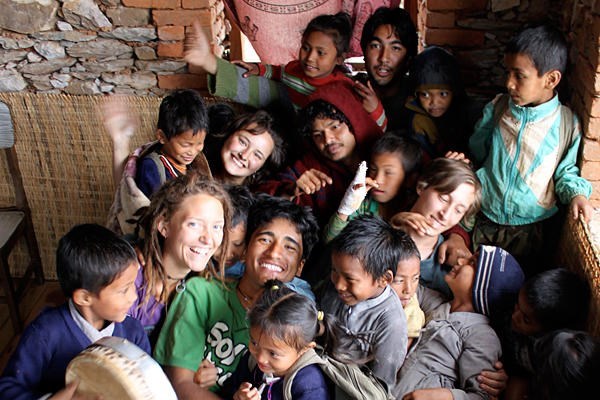 Surya Karki (c., green T-shirt), cofounders, and volunteers at Maya Universe Academy in Tanahun, Nepal, huddle with children enrolled at their school. <P> Joseph D. Layden/Maya Universe Academy