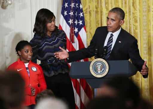 President Barack Obama, with first lady Michelle Obama and Olympic gold medal gymnast Simone Biles speaks in the East Room of the White House in Washington, Thursday, Sept. 29, 2016, after being presented with a surf board signed by the U.S. 2016 Olympians during a ceremony honoring the members of the 2016 United States Summer Olympic and Paralympic Teams. (AP Photo/Manuel Balce Ceneta)