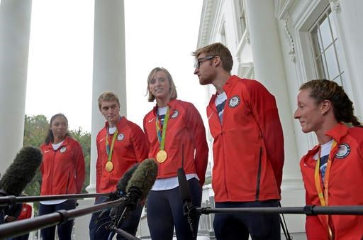 Olympic gold medal winner swimmer Katie Ledecky, center, accompanied by, from left, Olympic runner Allyson Felix, Olympic BMX rider Connor Fields, Paralympic Swimmer and Navy veteran Brad Snyder, and Paralympic wheelchair racer Tatyana McFadden, speaks outside the White House in Washington, Thursday, Sept. 29, 2016, following a ceremony where President Barack Obama honored the Olympics teams. (AP Photo/Susan Walsh)