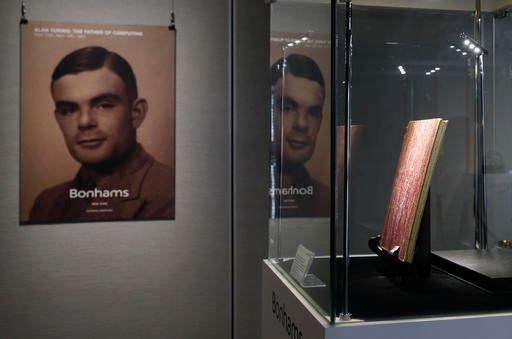 In this Thursday, March 19, 2015 file photo, a notebook of British mathematician and pioneer in computer science Alan Turing, the World War II code-breaking genius, is displayed in front of his portrait during an auction preview in Hong Kong. Britain's government will posthumously pardon thousands of gay and bisexual men convicted under long-repealed anti-gay laws. The calls for a more sweeping action came after World War II codebreaker Alan Turing was awarded a posthumous royal pardon in 2013 after a conviction of indecency in 1952. The gay computer science pioneer was stripped of his security clearance and later committed suicide. (AP Photo/Kin Cheung, File)