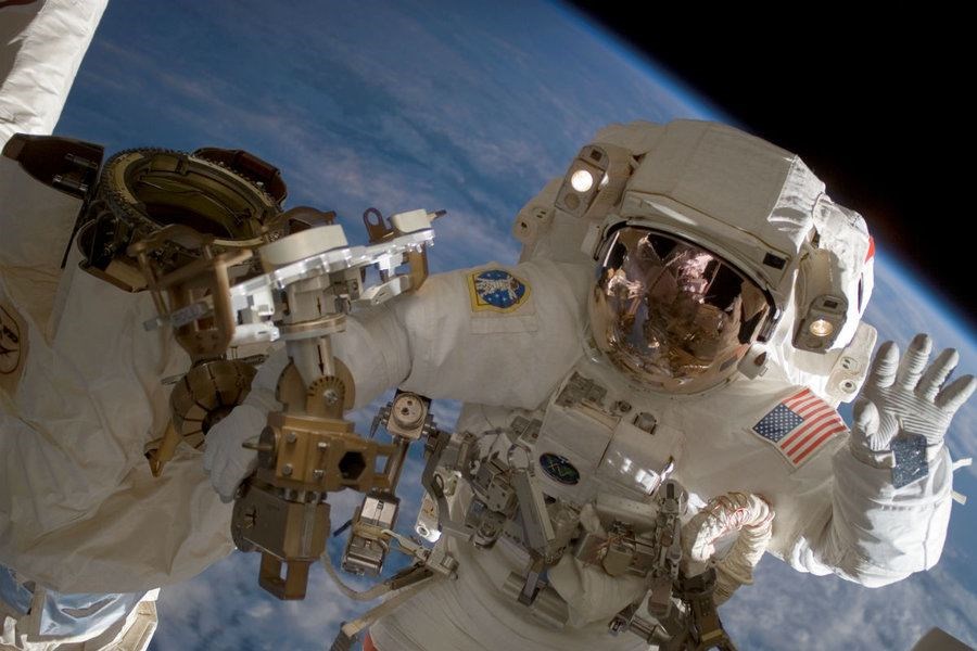 Astronaut Clay Anderson waves during a spacewalk outside the International Space Station. Astronauts traveling to and from Mars would be bombarded with as much cosmic radiation as they’d get from a full-body CT scan about once a week for a year, researchers reported in 2013. (NASA/AP photo)