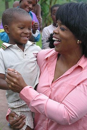 Oprah in South Africa with a young little child