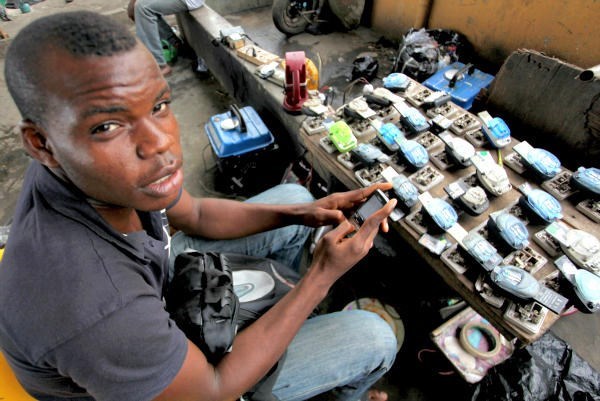 Jamil Idriss charges 50 naira ($0.33) to recharge phone batteries by plugging them into a diesel generator in Lagos, Nigeria. Most of Nigeria is hampered by constant power outages, meaning his customers can't charge their own phones. Multifunction diesel generators are helping generate electricity and do other kinds of work all over Africa.  <P>Akintunde Akinleye/Reuters/File