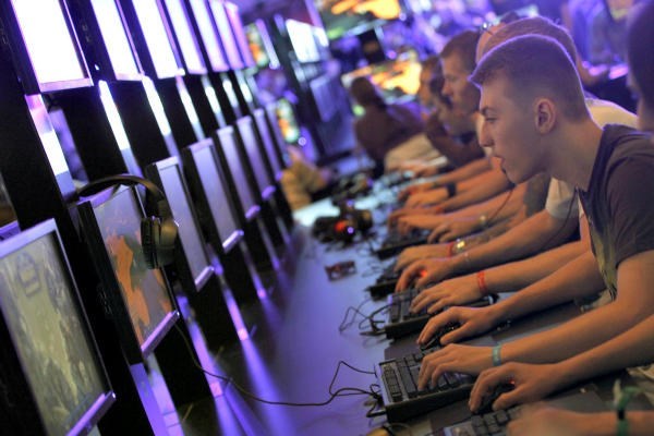 Visitors play World of Warcraft during the Gamescom 2011 fair in Cologne, Germany. By the time average Americans turn 21, they have played 10,000 hours of video games. Games for Change advocates using some of that time on games that result in social good.  <P>Ina Fassbender/Reuters/File